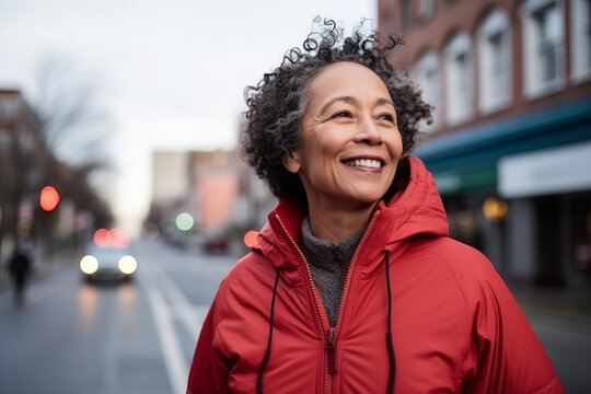 Portrait of a happy senior woman in red jacket smiling on a street