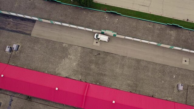 Male entering a white van. Aerial above a rental public storage.