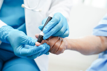 Asian doctor using lancet pen on senior patient finger for check sample blood sugar level to treatment diabetes. - obrazy, fototapety, plakaty