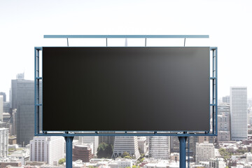 Blank black billboard on cityscape background, front view. Mock up, advertising concept