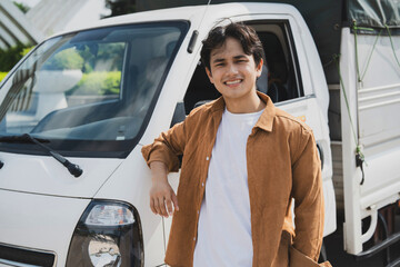 Photo of young Asian man with his truck