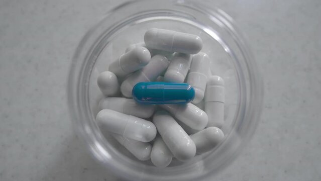 Many pill close-up isolated white background. Person take tablet medicine. One blue capsule inside bottle. Covid 19 virus bio drug. Health care concept. A lot of man heal flu ill. Body therapy pilule
