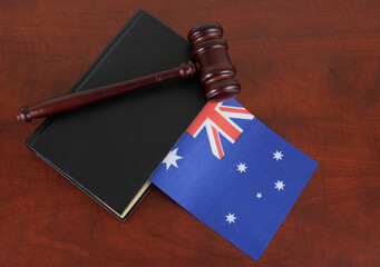 Judge gavel and legal book on wooden table with flag of Australia