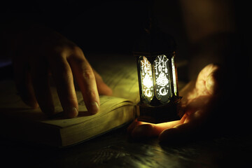 Ornamental Arabic lantern with burning candle glowing at night. Festive greeting card, invitation...
