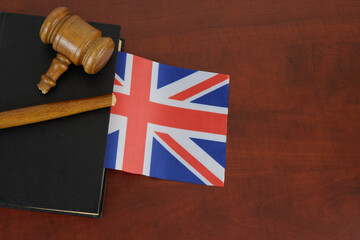 Broken gavel and legal book with British flag on wooden table. Problems in legal system of UK. Copy...