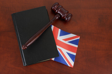 Gavel and legal book on wooden table with british flag. 