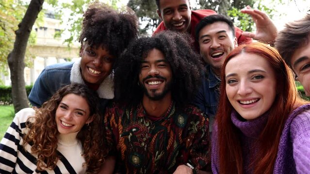 group of smiling multiracial teenage friends taking selfies during a peace march