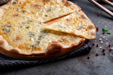 Pizza four cheeses on a dark background. Pizza 4 cheeses with gorgonzola, cheddar, mozzarella and parmesan. Close-up