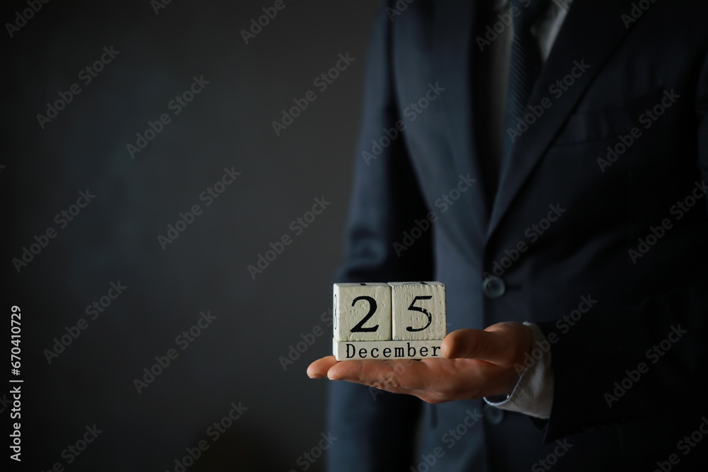 Wall mural portrait of businessman ready for christmas. wooden cubes with inscription 25 december