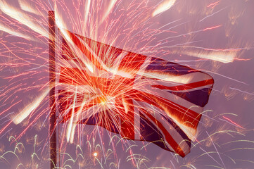flag of the United Kingdom on flagpole against fireworks