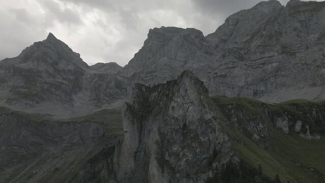 Drone footage of the mountains around the Bannalpsee reservoir under cloudy sky, Switzerland