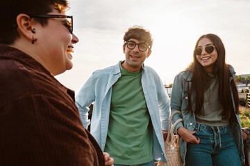 Close-up of a group of young friends, laughing and enjoying their time together outdoors during a...