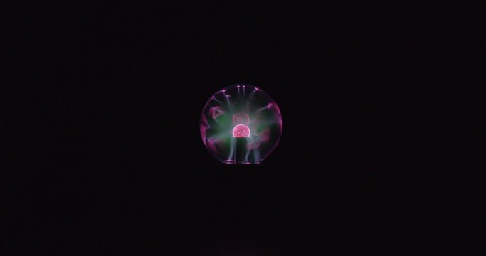 This is a far shot video of a plasma globe running with a black background