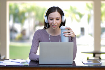 Female university students working on laptops and doing homework.