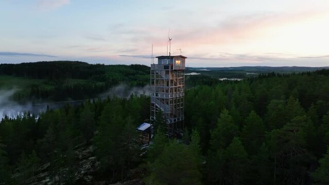 Aerial view orbiting the Haahninmaen nakotorni tower, misty morning in Finland