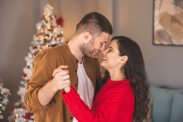 Couple dancing while spending Christmas day together at home