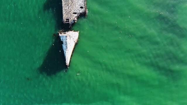 Aerial view over a shipwreck in sunny Rio del Mar, USA - top down, drone shot
