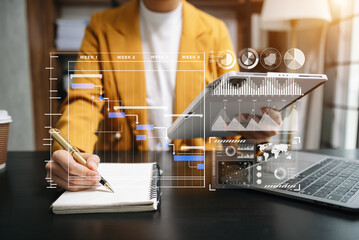 Businessman hand Project manager working and update tasks and Gantt chart scheduling virtual diagram.with smart phone, tablet and laptop