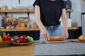Happy young woman practicing bread making in her home kitchen.