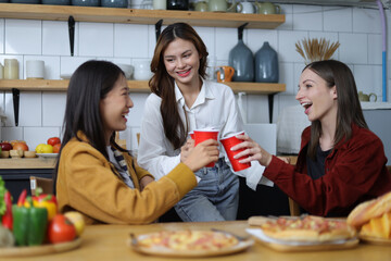 Young woman and friends having a small party in the kitchen at home.