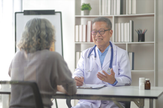 Senior health care concept. Doctor with patient in medical office. Retired woman sits in a hospital examination room while discussing his health with a doctor.