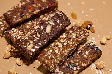 Healthy vegan bars with dried fruits and nuts on brown background