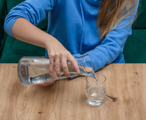 Nalewać wodę ze szklanego dzbanka do szklanki, w restauracji - obrazy, fototapety, plakaty