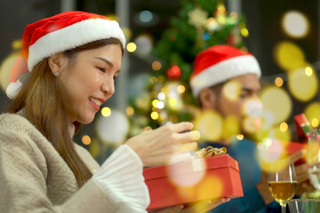 Group of diverse ethnicity people enjoy celebrating a Christmas Eve and New Year party together, friends exchanging a presents together in Christmas Eve and New Year festival party.