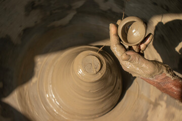 Indian potter making small pot or Diya for Diwali with clay on potters wheel Hand work craft
