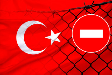image symbolizes topics related to migration policies and border control, depicting national Turkish flag, prohibition sign, and barbed wire, political restrictions