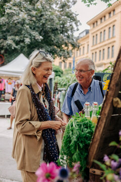 Happy senior couple at farmer's market in city