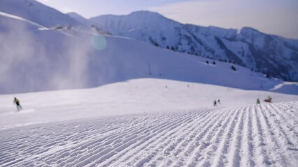 Close-up straight line rows of freshly prepared groomed ski slope piste. Prepared snowcat trail on a background of mountains. Snowcapped mountain downhill landscape at winter skiing resort. - Powered by Adobe