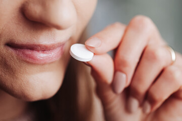 White pill in fingers. Woman holding drug. Narcotics background. Young girl taking drugs. Hand holding white tablet. Illness cure. Medication dose. Painkiller problem. Closed mouth smile and tablet. - obrazy, fototapety, plakaty
