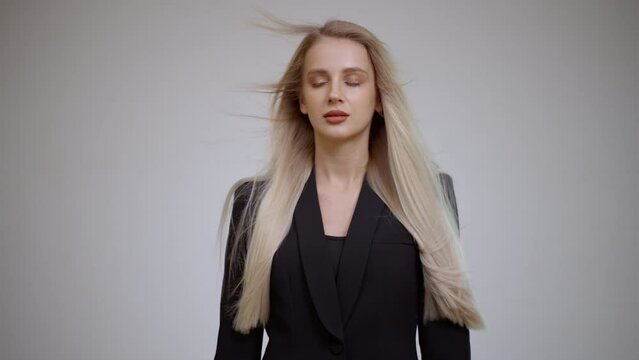 Luxurious long blonde hair in motion. Gray background.