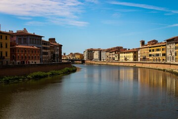 Fototapeta na wymiar Picturesque view of a large body of water set against a backdrop of architecture in Pisa, Italy
