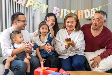 Portrait of happy love asian big family father and mother with asian baby and little girl happy birthday, party, celebration, cake, surprise, grandfather with grandmother smiling together.Family party