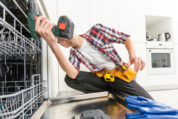 A new pump for dishwasher in the hands of a men, against the background of a disassembled dishwasher