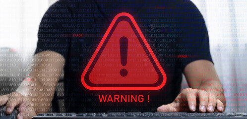 Businessman typing on computer keyboard with error message Virtual red warning label between binary codes for error notification. Maintenance and errors in writing software code concepts