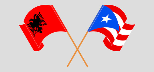 Crossed and waving flags of Albania and Puerto Rico