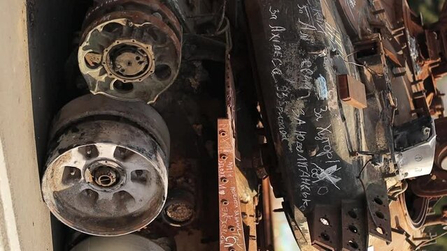 tracks and wheels of a burnt Russian tank. Side view of the tracks of a damaged Russian tank on a city street, Ukraine. The remains of a burnt out and damaged Russian army tank. war in Ukraine