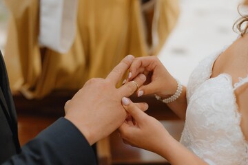 Exchange of rings of bride and groom. Unrecognizable bride puts ring on groom's finger.Newlyweds.