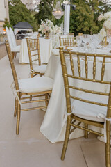 Arrangement of tables on outdoor terrace, wedding event. Wedding in classic style. Table linen.