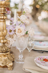 Fragment of decor of wedding table in classic style, bronze cast vintage candlestick, crystal .