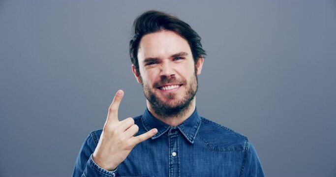 Man, face or excited with rock gesture for concert, punk and crazy with shouting expression in studio. Person, portrait or horn hands with screaming, happiness and rocker on gray background or mockup