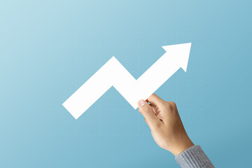 A man holding arrows pointing up with graph as a symbol of growth and success or rising successful...