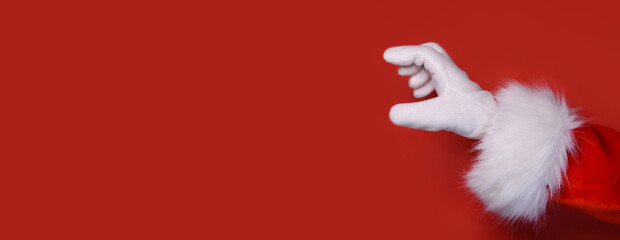 Santa Claus hand presenting your text, product, advertisement on a red background.Mockup. Copy space. Banner