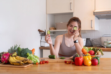 Young Asian healthy beautiful woman with casual clothes is smile and slicing fresh fruit to diet at home in kitchen in holiday