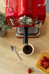 Cup of coffee, bonsai, red coffee maker, coffee spoon
  on a wooden surface