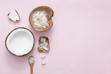 Fresh coconuts in different shapes and wooden spoons are displayed on a minimalist background. Copy space for commercial purposes. Top view,