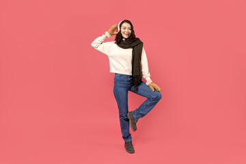 Beautiful girl in warm, winter clothes on a pink background. - obrazy, fototapety, plakaty